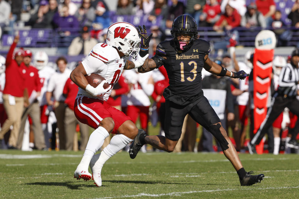 Wisconsin running back Braelon Allen, left, runs with the ball against Northwestern defensive back Garnett Hollis Jr., right, during the first half of an NCAA college football game on Saturday, Oct. 8, 2022, in Evanston, Ill. (AP Photo/Kamil Krzaczynski)