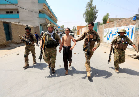 Afghan security forces escort a slightly injured boy at the site of gunfire and attack in Jalalabad city, Afghanistan July 11, 2018. REUTERS/Parwiz