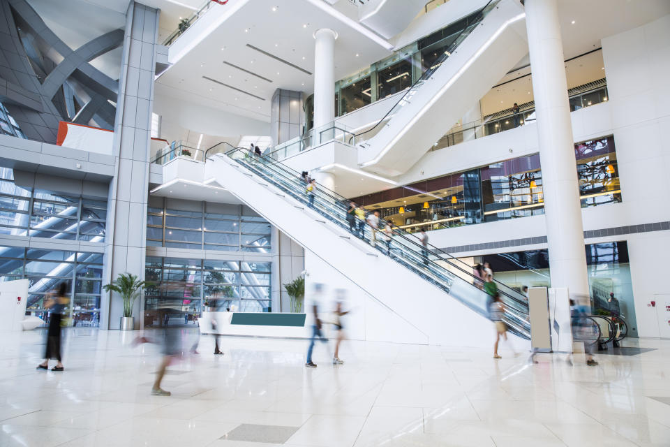 An interior view of a busy multilevel mall with a lot of shoppers.