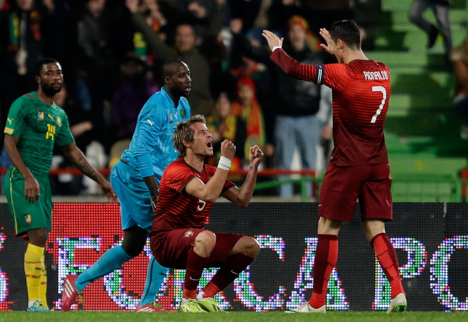Portugal's Fabio Coentrao celebrates with Cristiano Ronaldo, right, after scoring their side's third goal during their friendly soccer match with Cameroon Wednesday, March 5 2014, in Leiria, Portugal. The game is part of both teams' preparation for the World Cup in Brazil. Portugal defeated Cameroon 5-1. (AP Photo/Armando Franca)