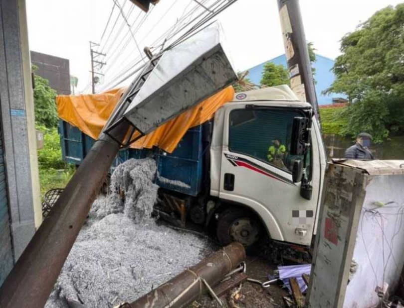 桃園市楊梅區一輛大貨車自撞電線桿，造成電桿斷裂，同時波及電桿旁商家招牌及機車，現場一片狼藉令人怵目驚心。(圖／讀者提供)