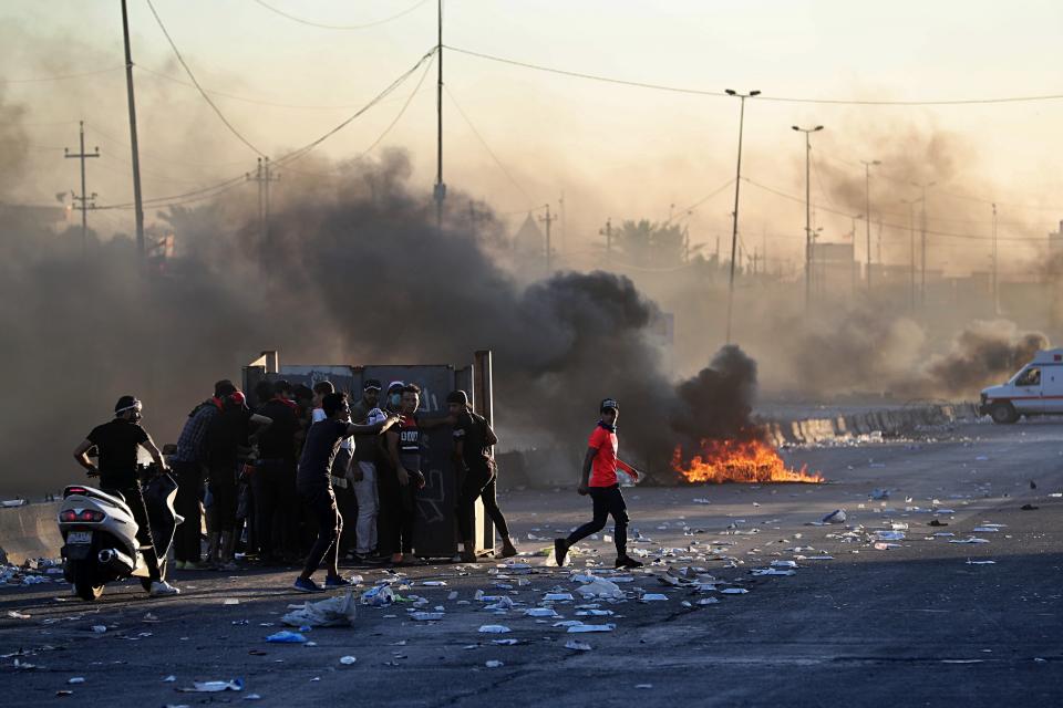 Anti-government protesters set fires and close a street during a demonstration in Baghdad, Iraq, Friday, Oct. 4, 2019. Security forces opened fire directly at hundreds of anti-government demonstrators in central Baghdad, killing some protesters and injuring dozens, hours after Iraq's top Shiite cleric warned both sides to end four days of violence "before it's too late." (AP Photo/Khalid Mohammed)