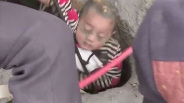 Video has captured the moment the tiny boy emerged from the earth after two hours underground with one arm raised above his head in a 'Superman'-like position. Photo: CCTV News