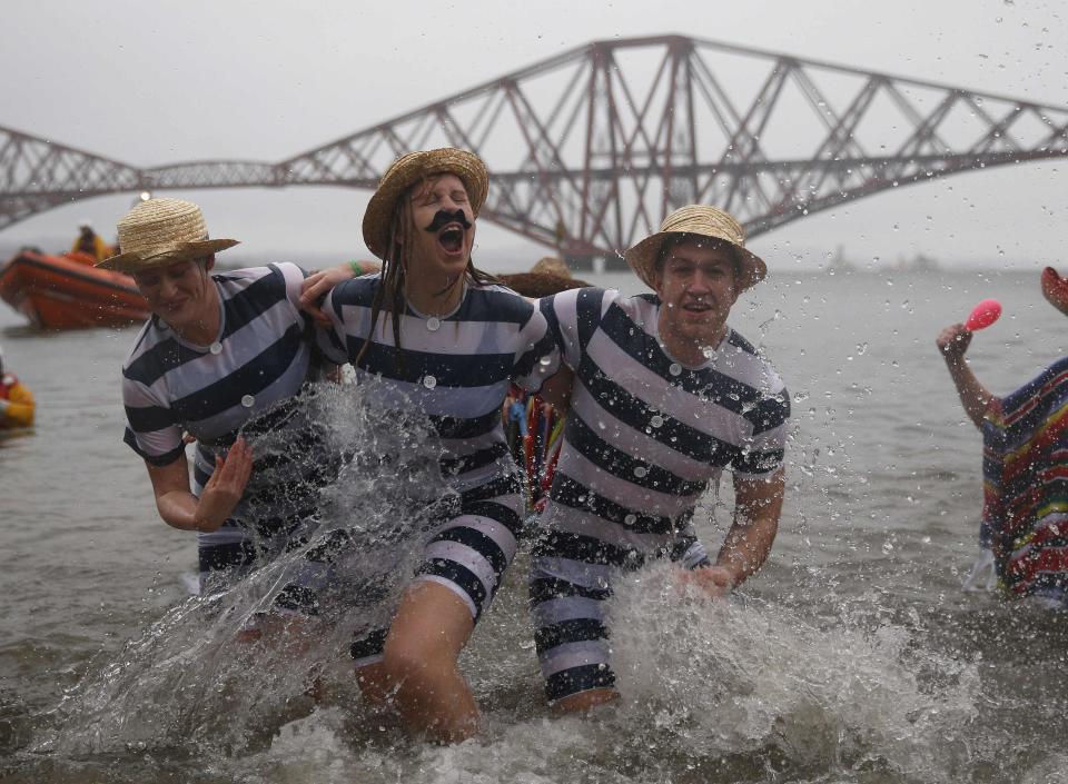 Swimmers in fancy dress splash as they participate in the New Year's Day Loony Dook swim at South Queensferry, Scotland