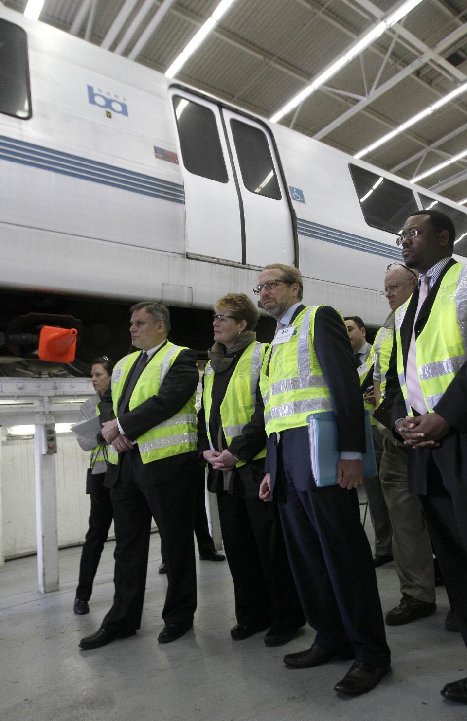 In this photo taken Wednesday, April 11, 2012, Federal Transit Administrator Peter Rogoff, second from right, and Bay Area Rapid Transit (BART) General Manager Grace Crunican, second from left, and others, stand near a BART train during a tour of the BART Maintenance Yard in Hayward, Calif. Driven by high gas prices and an uncertain economy, Americans are turning to trains and buses to get around in greater numbers than ever before. The aging trains and buses they’re riding, however, face an $80 billion maintenance backlog that jeopardizes service just when it’s most in demand. (AP Photo/Jeff Chiu)