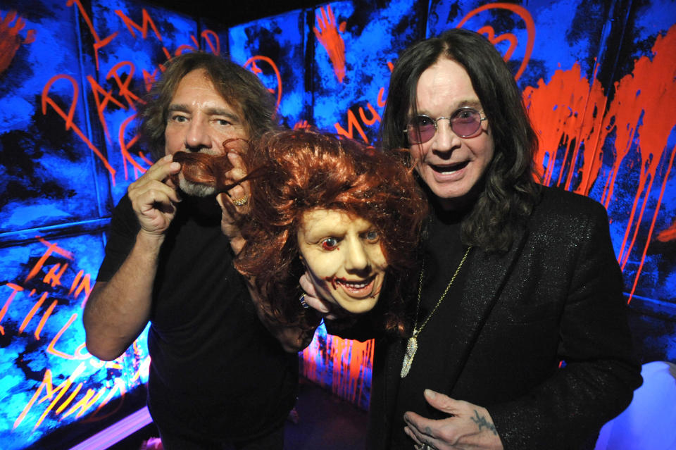 In this Tuesday, Sept. 17, 2013 photo, Geezer Butler, left, and Ozzy Osbourne pose with props at the "Black Sabbath: 13 3D" maze at Universal Studios Halloween Horror Nights, in Universal City, Calif. Several spooks at this year's Halloween Horror Nights are hyping new releases from the entertainment industry. Besides "13" from Sabbath, there's a "scare zone" populated by actors dressed as the nasty Chucky doll from the direct-to-DVD sequel "Curse of Chucky," and a new maze incorporating supernatural elements from the "Insidious" films. (Photo by John Shearer/Invision/AP)