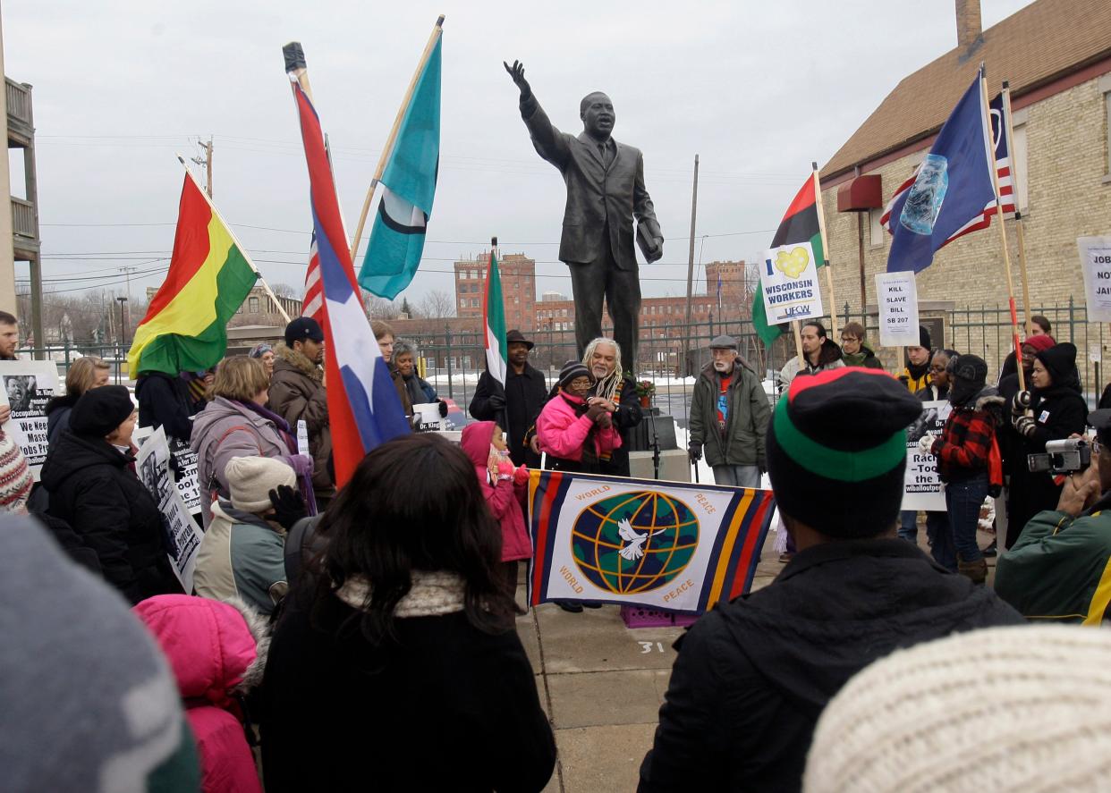 A crowd gathers to celebrate Martin Luther King Day in 2023 in Milwaukee near a statue of his likeness.