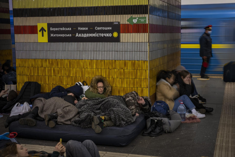 Residents of all ages, including a woman in a fur hood, lie huddled in the Kyiv subway.