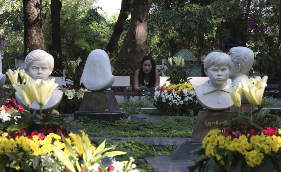 In this Friday, Oct. 18, 2019, photo, a Catholic devotee prays at the busts of Cecilia Butsiat, front left, and Maria Phon, front right, at the seven martyrs cemetery during the 30th anniversary of the beatification of seven martyrs at Songkhon village in Mukdahan province, in northeastern Thailand. In 1940, seven villagers here were executed for refusing to abandon their Catholic faith, which Thai nationalists had equated with loyalty to France, whose colonial army in neighboring Indochina had fought Thailand in a brief border war. The seven were beatified in 1989 by Pope John Paul II, the first step to being named a saint.(AP Photo/Sakchai Lalit)