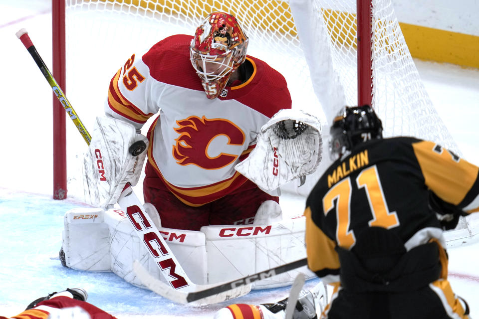 Pittsburgh Penguins' Evgeni Malkin (71) gets a shot past the blocker of Calgary Flames goaltender Jacob Markstrom (25) for a goal during the third period of an NHL hockey game in Pittsburgh, Saturday, Oct. 14, 2023. (AP Photo/Gene J. Puskar)