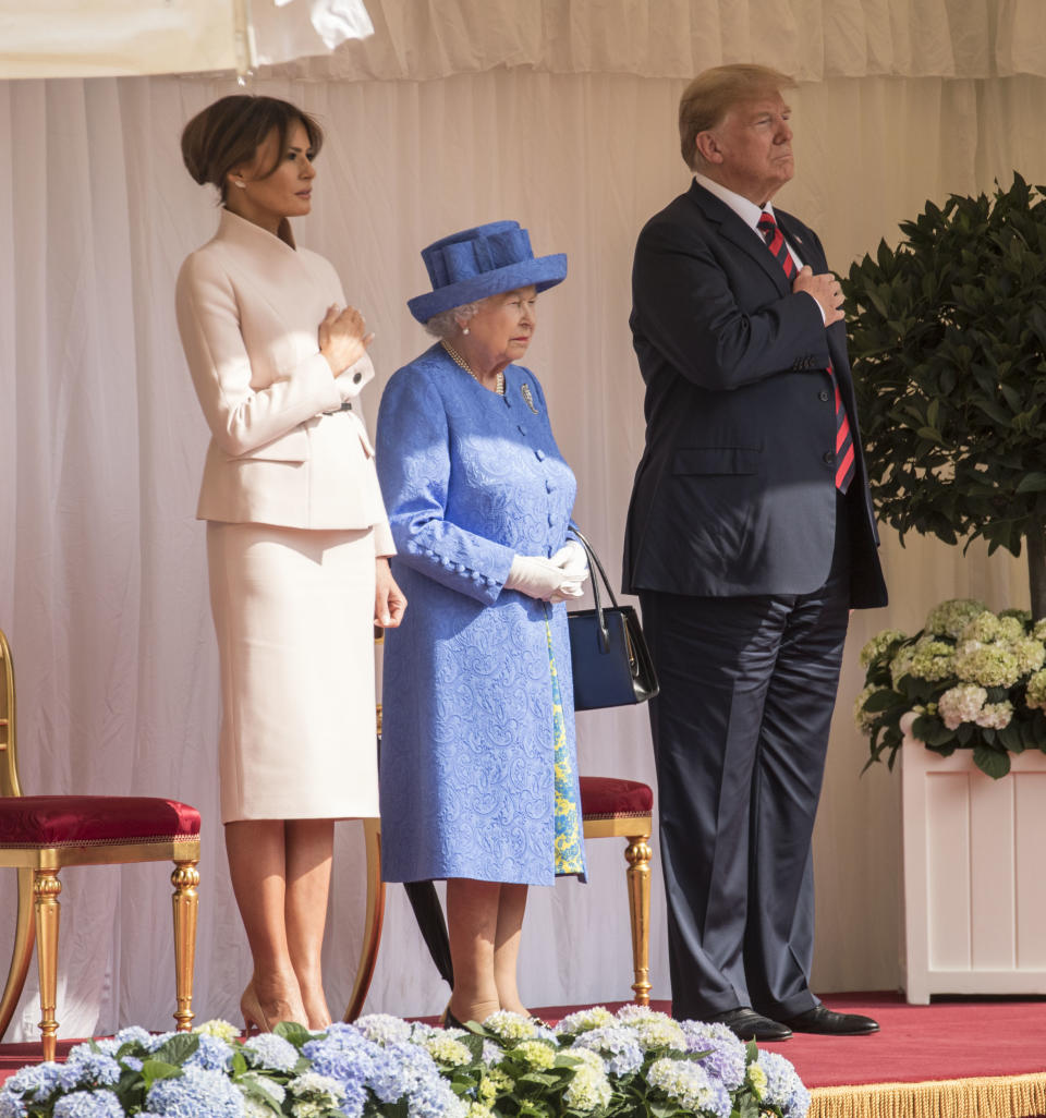 Britain’s Queen Elizabeth II, centre stands with US President Donald Trump and first lady Melania on the dias in the Quadrangle as they listen to the US national anthem, during a ceremonial welcome at Windsor Castle, Friday, July 13, 2018 in Windsor, England. The monarch welcomed the American president in the courtyard of the royal castle. (Richard Pohle/Pool Photo via AP)