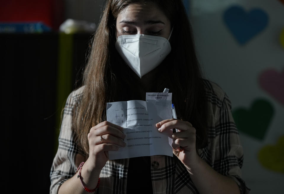 An electoral worker counts votes inside a polling station during presidential elections in Santiago, Chile, Sunday, Nov. 21, 2021. (AP Photo/Esteban Felix)