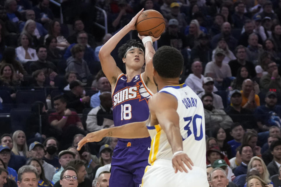 Phoenix Suns forward Yuta Watanabe (18) makes a 3-point basket against Golden State Warriors guard Stephen Curry (30) during the first half of an NBA basketball game in San Francisco, Tuesday, Oct. 24, 2023. (AP Photo/Jeff Chiu)