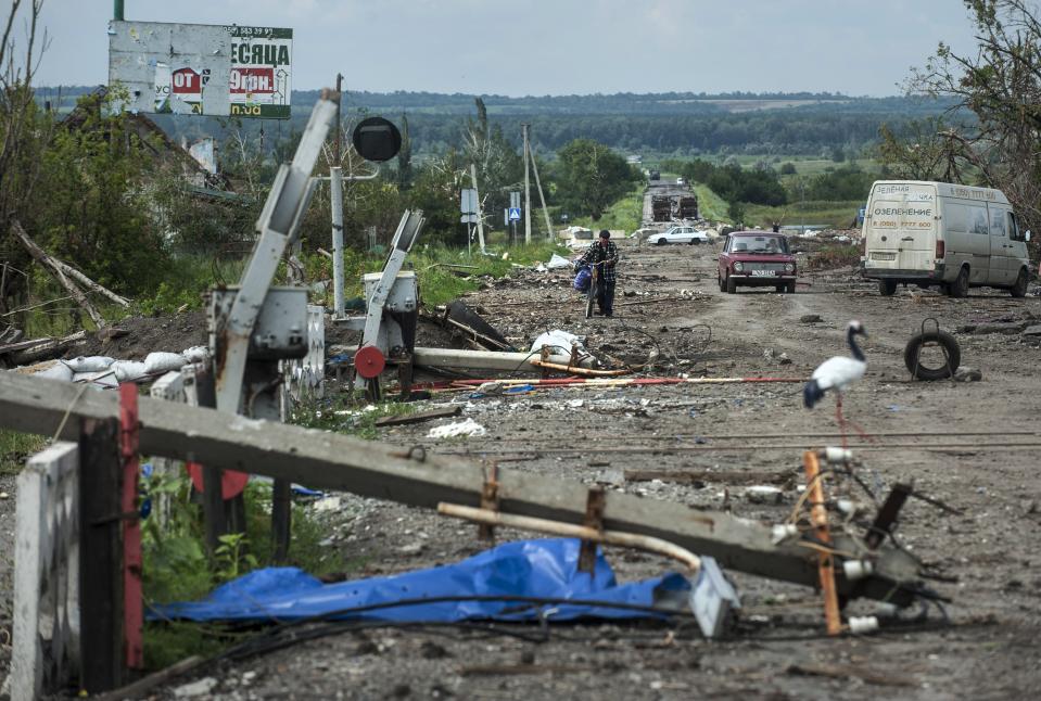 FILE - A local man walks through the rubbish after heavy fighting between pro-Russian fighters and Ukrainian government troops just outside Slovyansk, eastern Ukraine, Wednesday, July 9, 2014. (AP Photo/Evgeniy Maloletka, File)