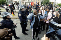 New York Police officers blocking an entrance to the Manhattan Bridge watch as a man leads a prayer with protesters calling for justice over the death of George Floyd, Wednesday, June 3, 2020, in the Brooklyn borough of New York. Floyd, an African American man, died on May 25 after a white Minneapolis police officer pressed a knee into his neck for several minutes even after he stopped moving and pleading for air. (AP Photo/Frank Franklin II)