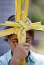 A woman holds palm fronds made into the shape of a cross during a Palm Sunday celebration outside the Metropolitan Cathedral in Managua, Nicaragua, Sunday, April 13, 2014. For Christians, Palm Sunday marks Jesus Christ's entrance into Jerusalem, when his followers laid palm branches in his path, prior to his crucifixion. (AP Photo/Esteban Felix)