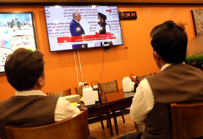 Afghans watch a live TV broadcast at a restaurant during an agreement signing ceremony between the U.S. and the Taliban in Kabul