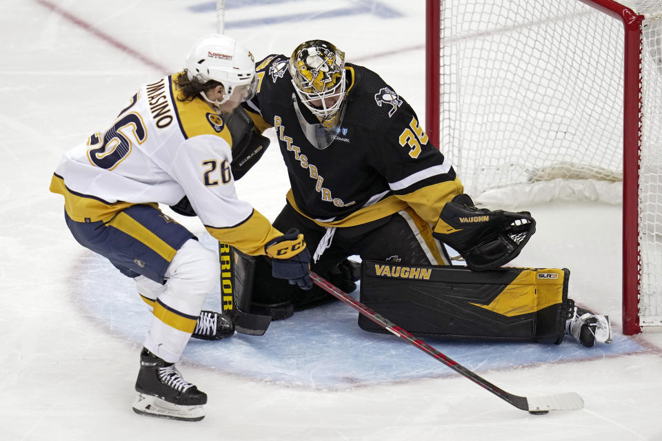 Pittsburgh Penguins goaltender Tristan Jarry (35) blocks a shot attempt by Nashville Predators' Philip Tomasino during the third period of an NHL hockey game in Pittsburgh, Thursday, March 30, 2023. (AP Photo/Gene J. Puskar)