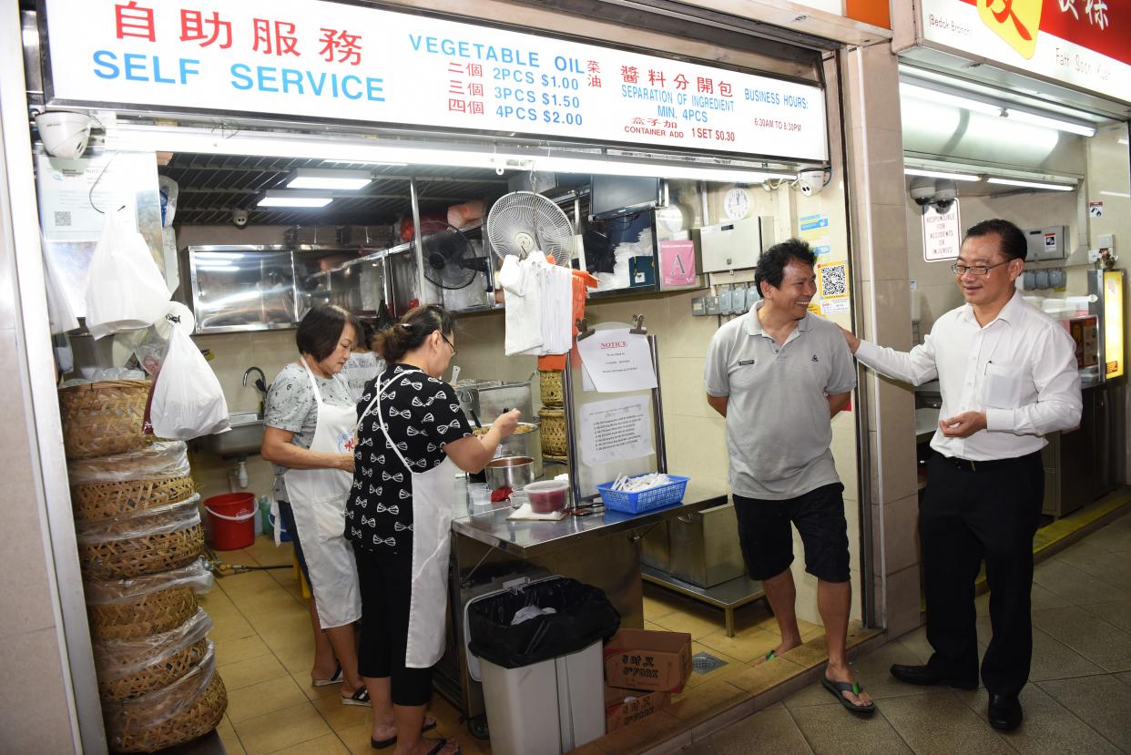 Seah Kian Peng (right), Group CEO of NTUC Enterprise, interacting with one of the hawkers at the Foodfare hawker centre. (PHOTO: FairPrice Group)