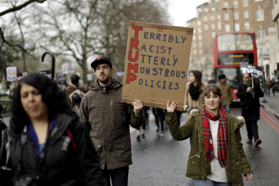 People hold a placard as they take part in a protest march in London, against U.S. President Donald Trump's ban on travellers and immigrants from seven predominantly Muslim countries entering the U.S., Saturday, Feb. 4, 2017. (AP Photo/Matt Dunham)