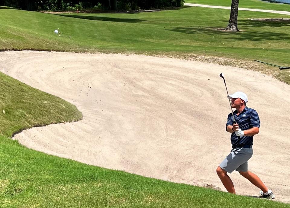 Jason Duff blasts the ball out of a greenside bunker at the 18th hole of the Deerwood Country Club on Saturday. He parred the hole to complete a final-round 64 to win the Jacksonville Amateur by 11 shots.