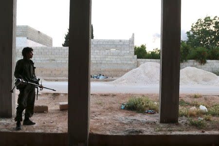 A rebel fighter stands with his weapon at a building after what activists said were clashes with Islamic State fighters in Soran Azaz, Aleppo countryside June 1, 2015. Picture taken June 1, 2015. REUTERS/Mahmoud Hebbo