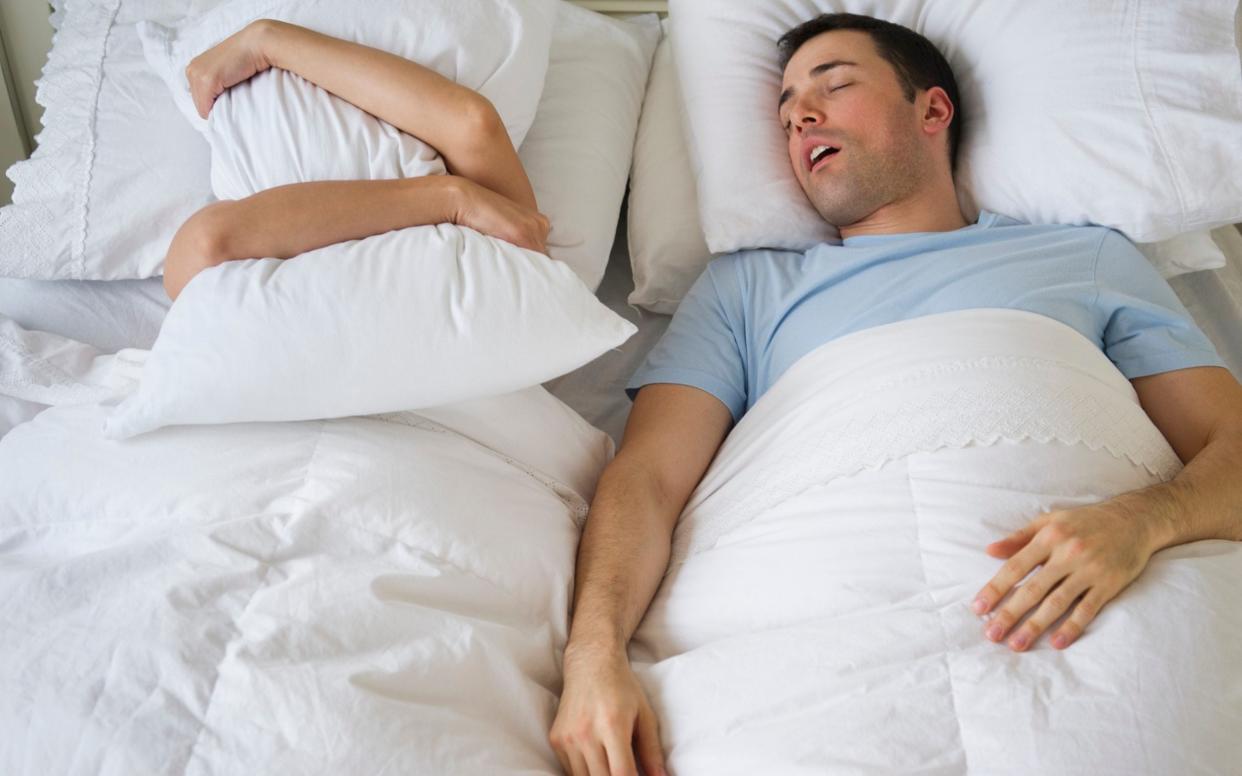 A man snores while his partner struggles to sleep