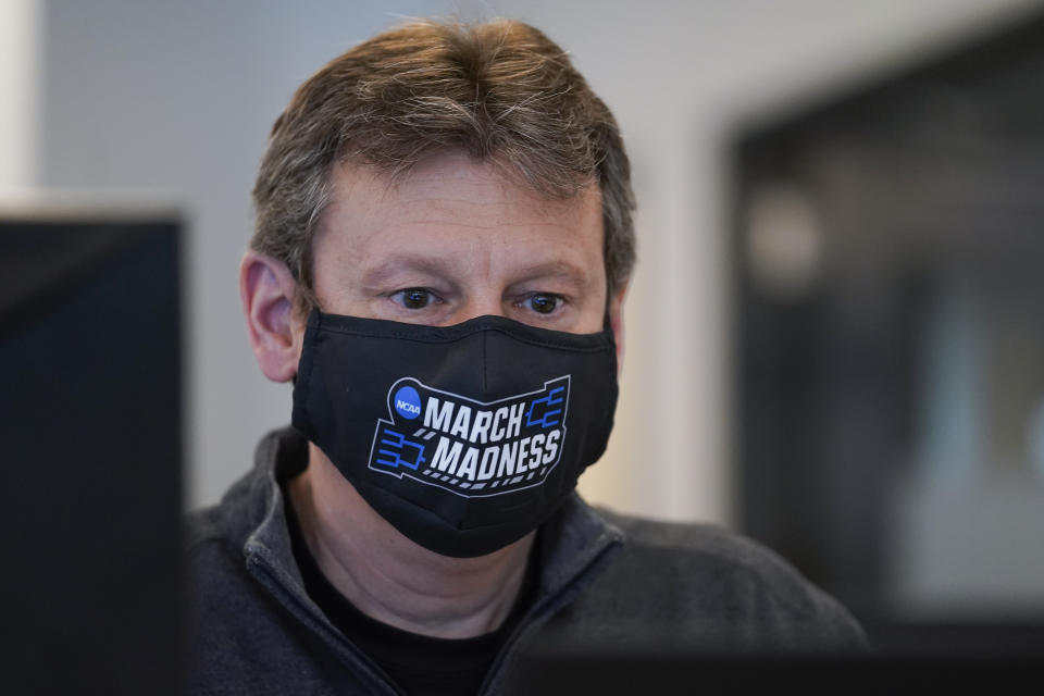 Brad Bowman reviews an order for a customer who is inside of the bubble while in town for the NCAA men's college basketball tournament, Tuesday, March 30, 2021, in Indianapolis. The NCAA and local organizing groups set up expanded ambassador and item-delivery services relying on volunteer help to take care of needs for players, officials and others working inside. (AP Photo/Darron Cummings)