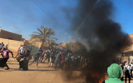 Sudanese demonstrators run from a teargas canister fired by riot policemen to disperse them as they participate in anti-government protests in Omdurman, Khartoum, Sudan January 20, 2019. REUTERS/Mohamed Nureldin Abdallah