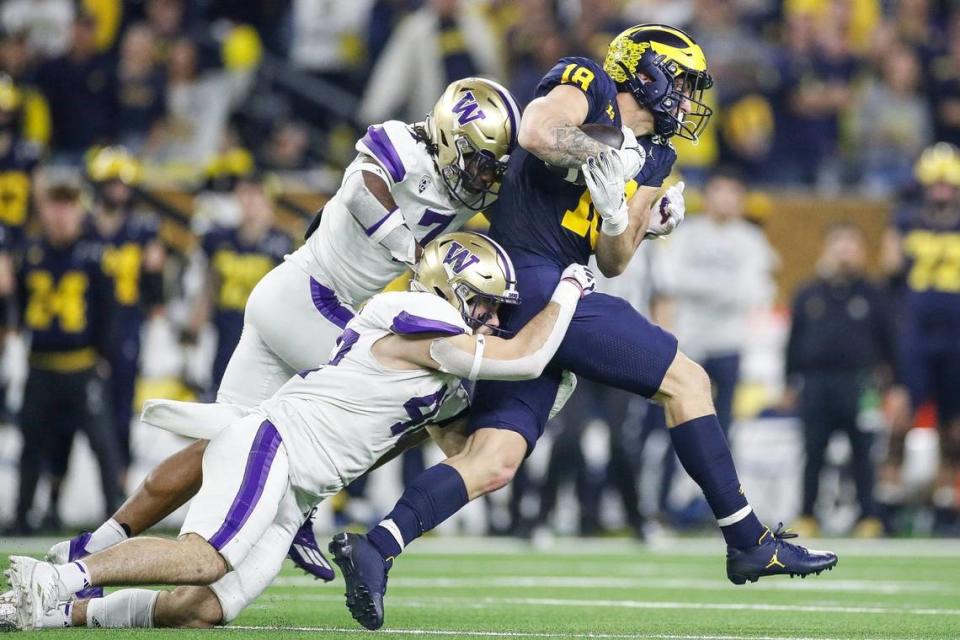 Michigan tight end Colston Loveland makes a catch against Washington linebacker Carson Bruener (42) and cornerback Dominique Hampton (7) during the first half Monday. Junfu Han/USA TODAY NETWORK