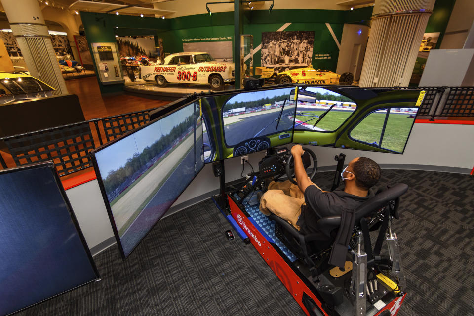 In this image provided by the The Henry Ford, a person tries the auto racing simulator, part of the Driven To Win exhibit at the The Henry Ford Museum in Dearborn, Mich. The “Driven to Win” exhibit took more than a decade from concept to its opening earlier this year. (Wes Duenkel/The Henry Ford via AP)