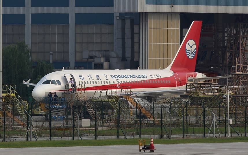 Maintenance crew inspect the Sichuan Airlines flight after it made an emergency landing on Monday - 2018 China News Service