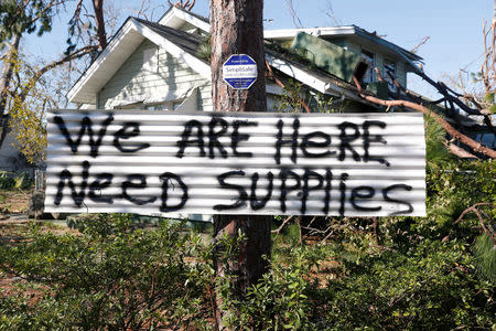 A sign hangs on a tree in front of a house damaged by Hurricane Michael in Panama City, Florida, U.S., October 13, 2018. REUTERS/Terray Sylvester