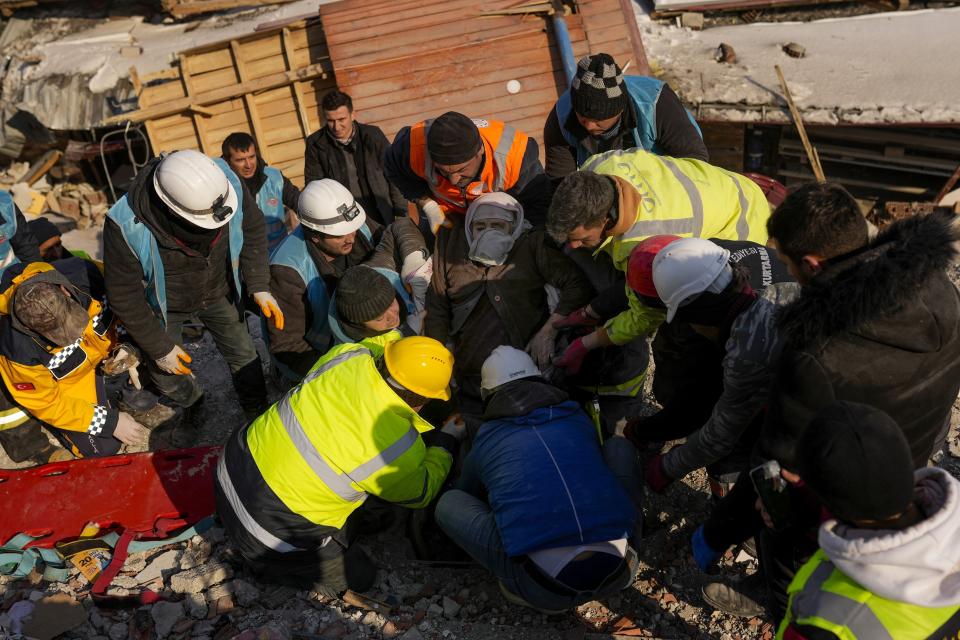 Turkish woman Hatice Korkut, center, 82, is rescued alive by rescue team members from a destroyed building in Elbistan, southeastern Turkey, Thursday, Feb. 9, 2023. Tens of thousands of people who lost their homes in a catastrophic earthquake huddled around campfires in the bitter cold and clamored for food and water Thursday, three days after the temblor hit Turkey and Syria. (AP Photo/Francisco Seco)