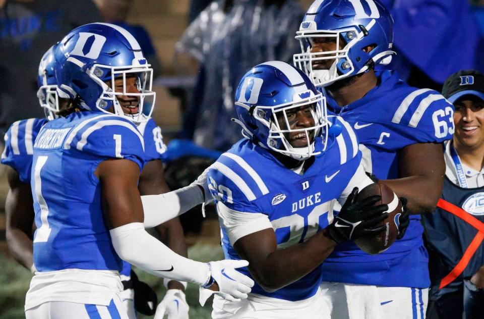 Duke’s Jaquez Moore (20) celebrates with Jontavis Robertson (1) and Jacob Monk (63) after scoring a touchdown against Virginia during the second half of an NCAA college football game in Durham, N.C., Saturday, Oct. 1, 2022. Ben McKeown/AP