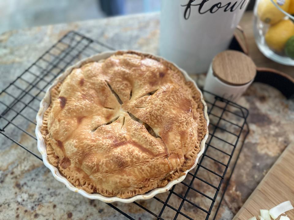 Baked pie with golden crust on metal cooling tray