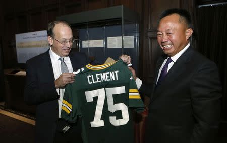 Attorney Paul Clement (L) is presented with a football jersey by his colleague Viet Dinh at a party in honor of Clement's 75th argument before the U.S. Supreme Court in Washington October 15, 2014. REUTERS/Yuri Gripas