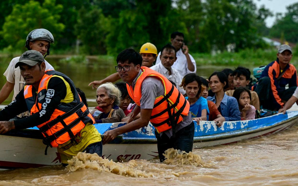 Flood-affected residents are transported on a rescue boat in Taungoo