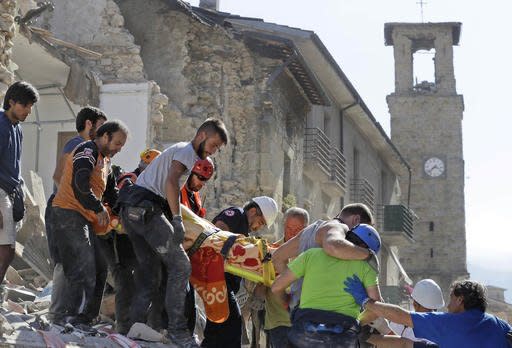 A victim is carried on a stretcher from a collapsed building after an earthquake, in Amatrice, central Italy, Wednesday, Aug. 24, 2016. A devastating earthquake rocked central Italy early Wednesday, collapsing homes on top of residents as they slept. At least 23 people were reported dead in three hard-hit towns where rescue crews raced to dig survivors out of the rubble, but the toll was expected to rise as crews reached homes in more remote hamlets. (AP Photo/Alessandra Tarantino)