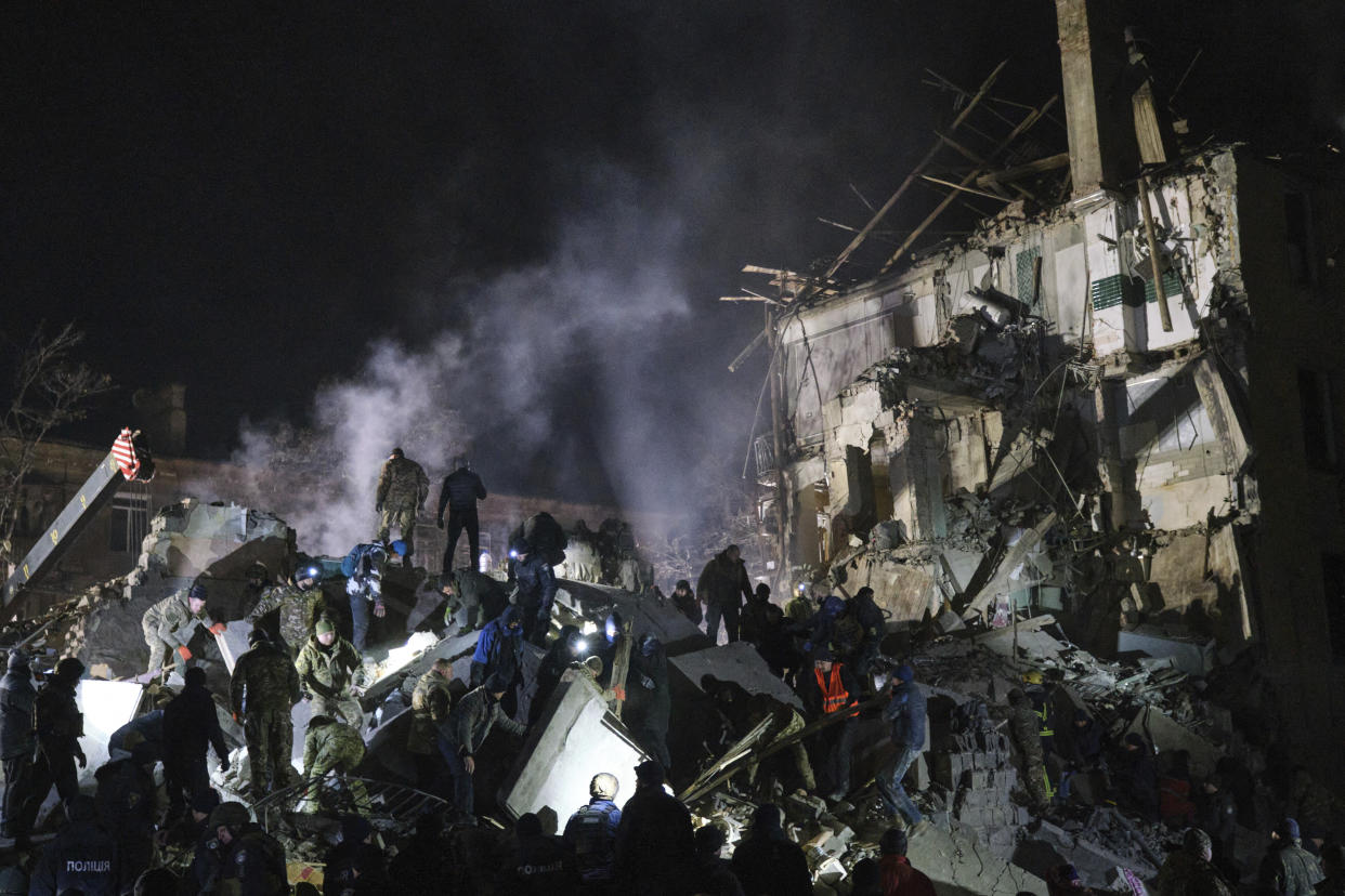 Emergency workers and local residents clear the rubble after a Russian rocket hit an apartment building in Kramatorsk, Ukraine, on Thursday, Feb. 2, 2023. (AP Photo/Yevgen Honcharenko)