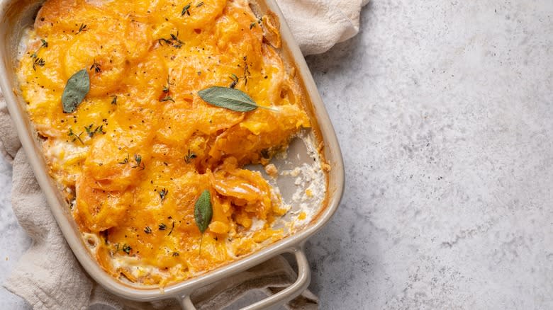 Sweet potato au gratin in pan with piece cut out 