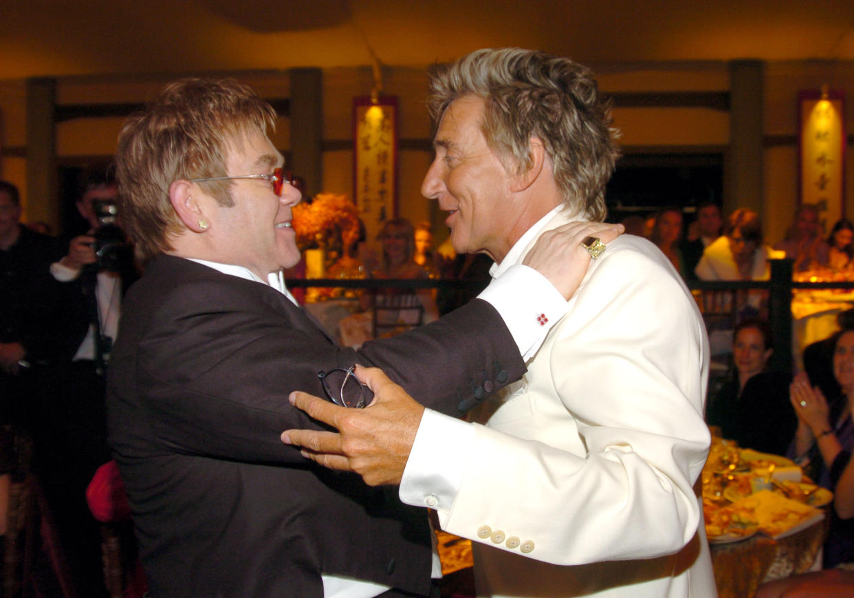 Sir Elton John and Rod Stewart. Sir Elton John has chosen to wear an emerald cut yellow diamond stud and an 42 ct emerald cut yellow diamond ring, as well as the Jumbo Happy Spirit pendant set with diamonds. (Photo by KMazur/WireImage for Chopard )