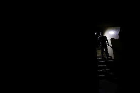 People use light from phones while they walk at the staircase of a building during a blackout in Caracas, Venezuela March 7, 2019. REUTERS/Carlos Garcia Rawlins