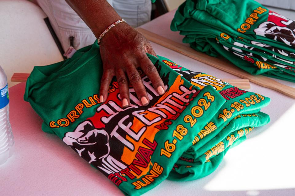 Festival shirts are unpacked from a box during the Juneteenth Festival at Water's Edge Park on Saturday, June 17, 2023, in Corpus Christi, Texas.