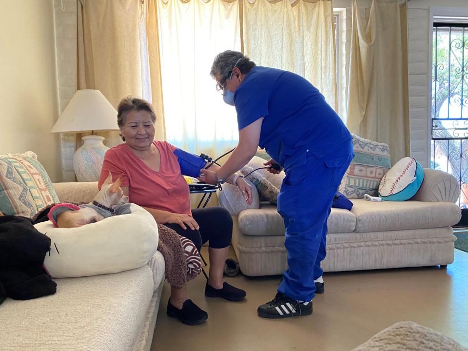In this May 15, 2020 photo provided by Shannon Todecheene her mother Carol Todecheene, left, receives therapy services at her daughter's home in Tucson, Ariz. Carol Todecheene was among those severely hit with the coronavirus. (Shannon Todecheene via AP)