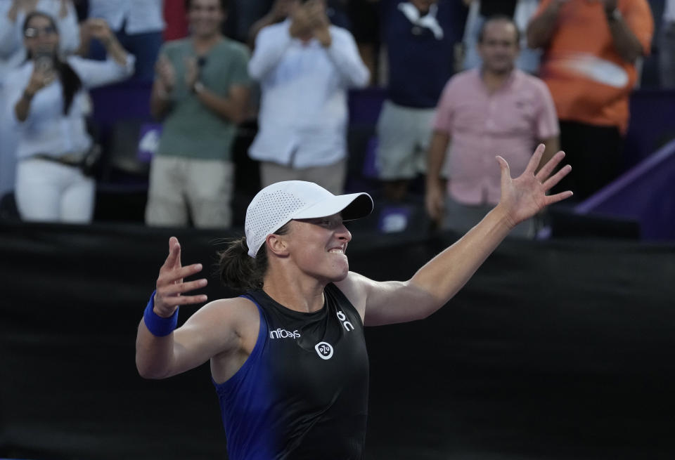 Iga Swiatek, of Poland, celebrates her victory over Jessica Pegula, of the United States, in the women's singles final of the WTA Finals tennis championships, in Cancun, Mexico, Monday, Nov. 6, 2023. (AP Photo/Fernando Llano)