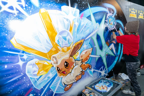 In this photo provided by Nintendo of America, artists from Overall Murals put the finishing touches on a Pokémon Scarlet and Pokémon Violet-themed mural at PAX East.