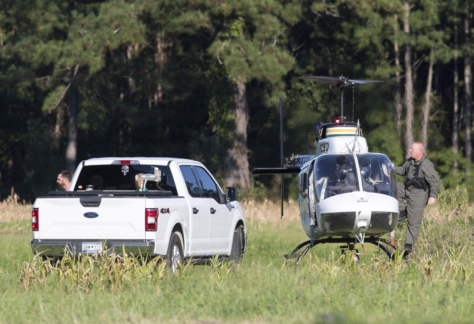 Pilots exit a Florence County Sheriff's Office helicopter after locating the position of a stealth fighter jet that crash-landed the previous day in a nearby field in Williamsburg County, S.C., on Monday, Sept. 18, 2023. (Henry Taylor/The Post And Courier via AP)