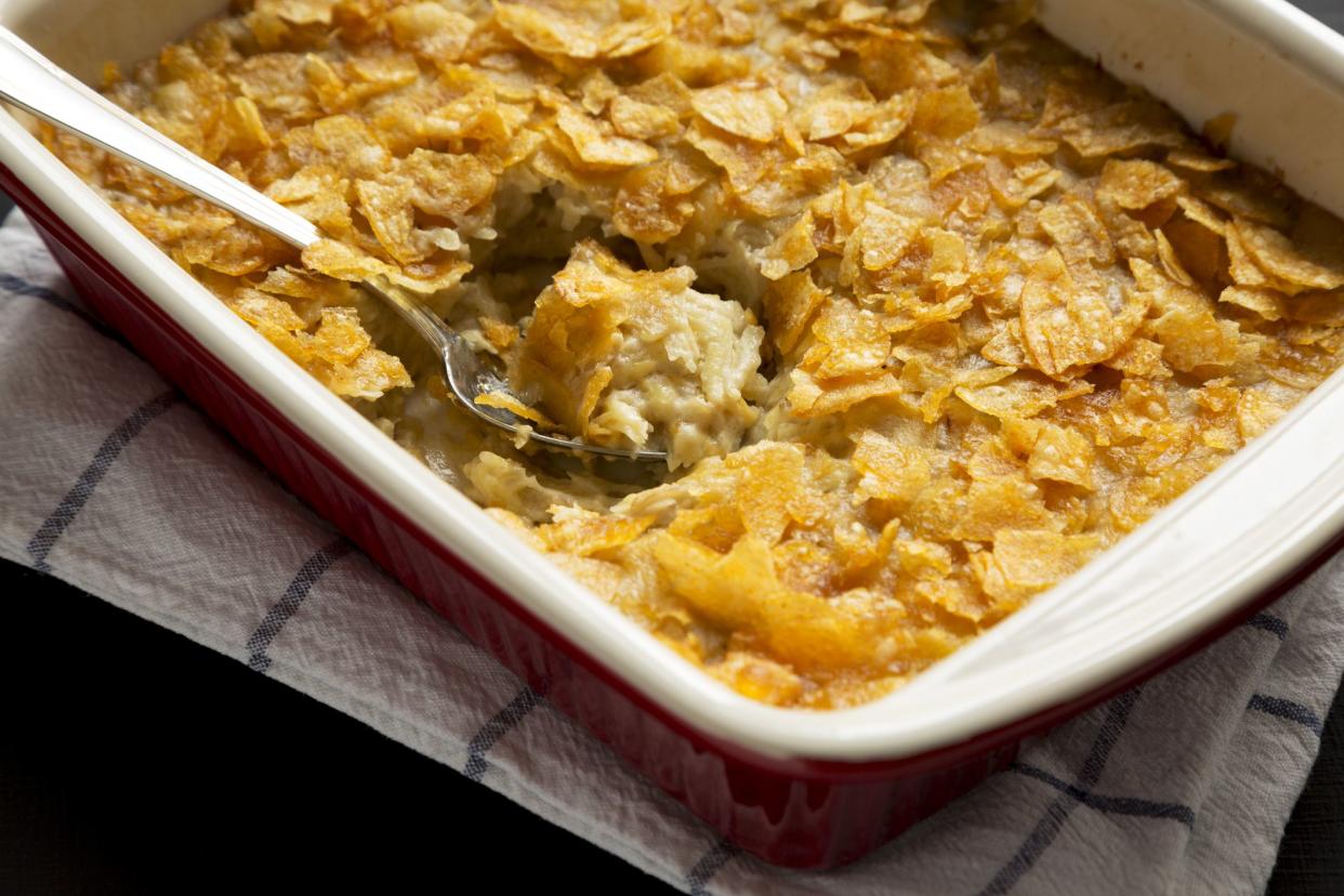 Cheesy Homemade Funeral Potatoes Casserole in a dish over black background