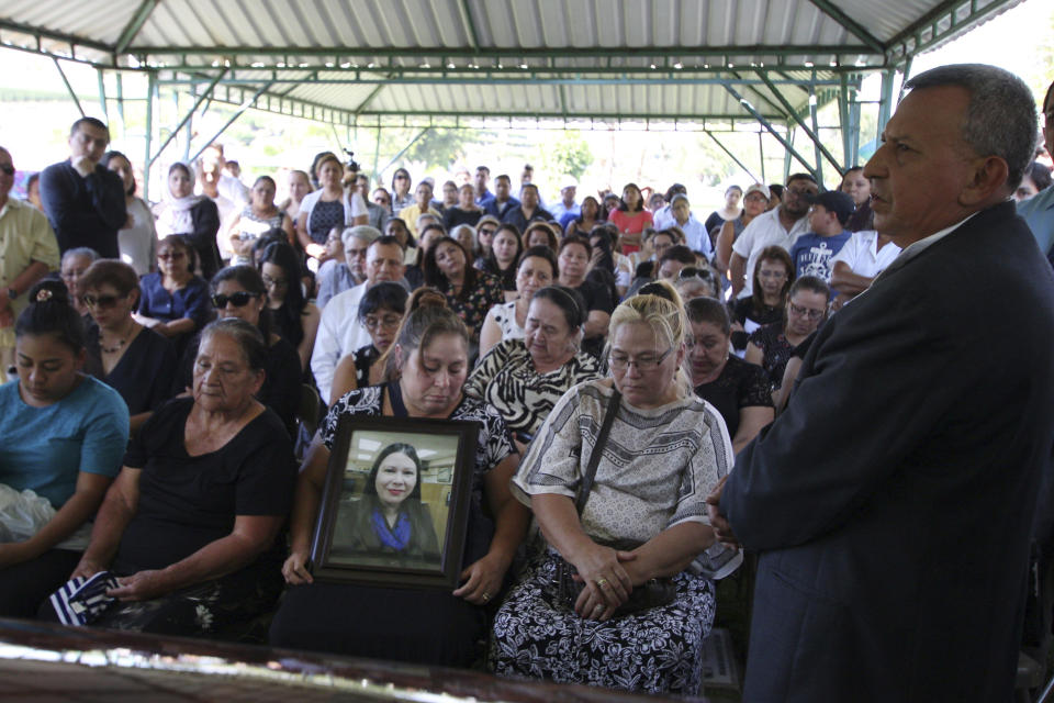 FILE - In this April 17, 2018 file photo, Demetrio Turcios, right, father of slain journalist Karla Turcios, addresses people attending Karla's funeral at the cemetery in San Salvador, El Salvador. The 33-year-old journalist, who worked for the magazine El Economista, owned by the La Prensa Grafica, was kidnapped on Saturday from her home and her body was found hours later on a highway. (AP Photo/Salvador Melendez, File)